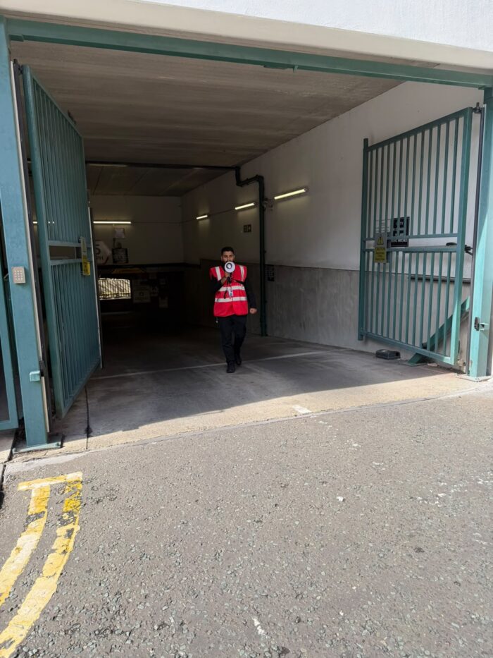 Ashridge waking watch officer patrolling the underground car park entrance at Bishop's Court, Spitalfields